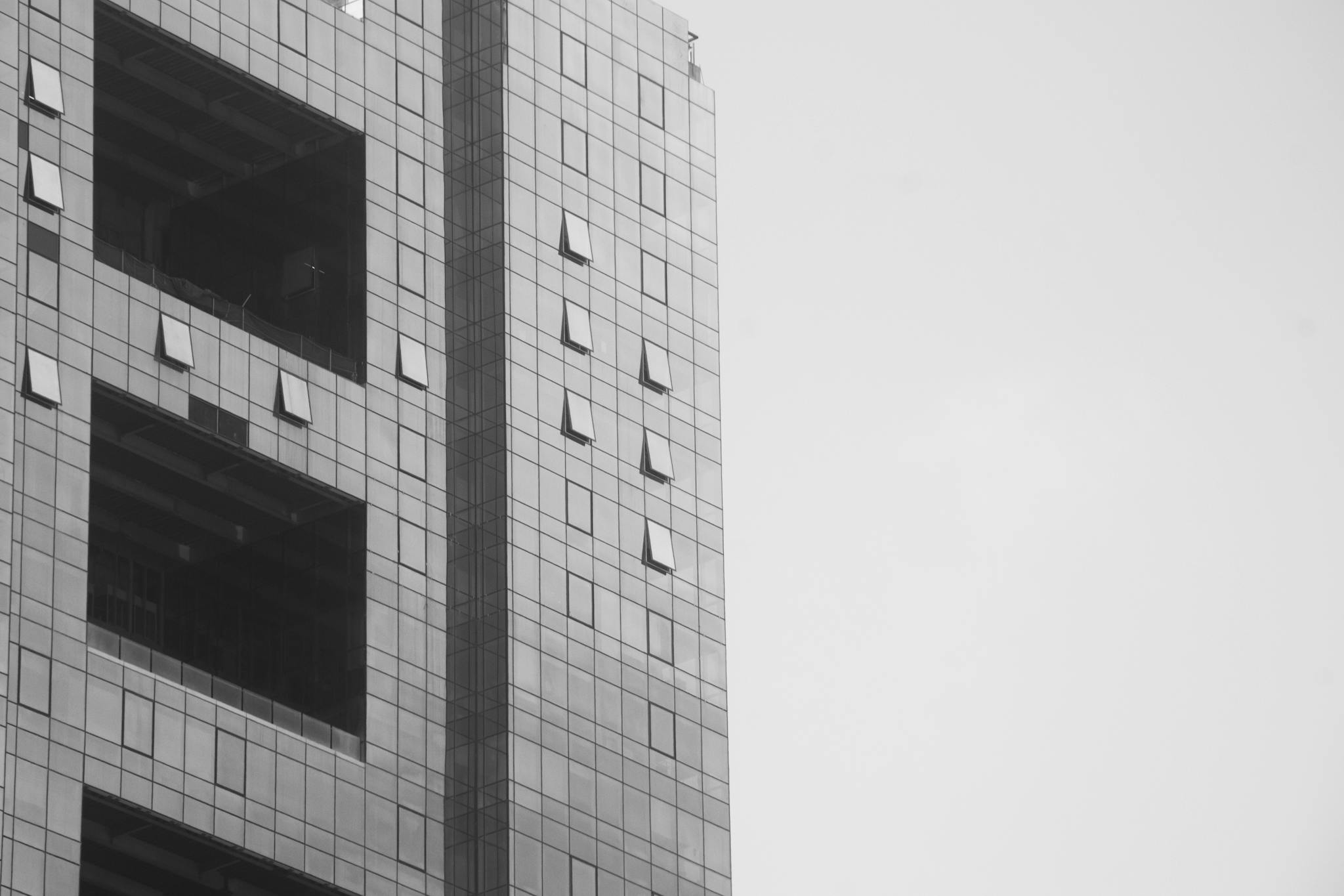 Black and white image of a modern skyscraper facade in Mumbai, showcasing geometric design.